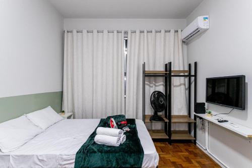 里約熱內盧的住宿－Temporada Flamengo - Metrô e Conforto!，一间酒店客房,配有一张床和一台电视,还有一间客房