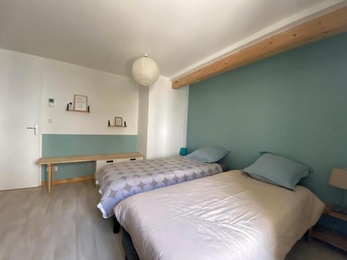 een slaapkamer met 2 bedden en een houten tafel bij La maison Familiale in Dijon