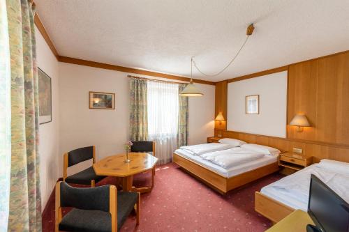 a hotel room with two beds and a table at Hotel Walter in San Candido