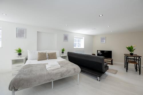 um quarto com uma cama, um sofá e uma televisão em Modern Studio Apartment Kings Lynn em King's Lynn