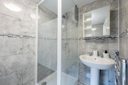a white bathroom with a sink and a shower at Modern Studio Apartment Kings Lynn in King's Lynn