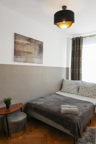 een slaapkamer met een bed, een tafel en een raam bij ClickTheFlat Three Crosses Square Apart Rooms in Warschau