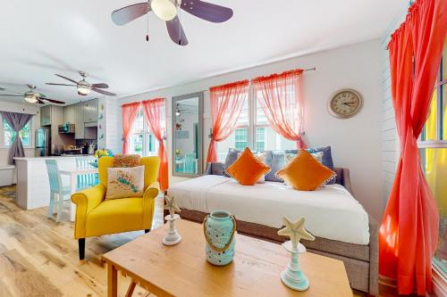 a bedroom with a bed and a yellow chair and a table at Egret House in Key West