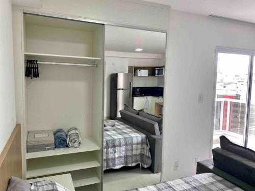 uma sala com um quarto com uma cama e um espelho em AP1422 ar condicionado piscina academia coworking etc em Juiz de Fora