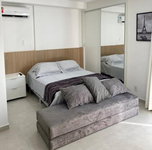 a bedroom with a large bed and a ottoman in it at AP822 ar condicionado piscina academia coworking etc in Juiz de Fora
