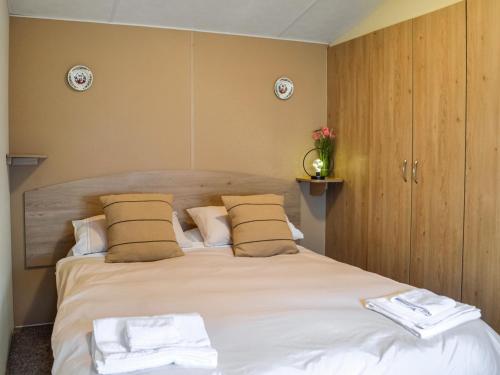 a bedroom with a bed with two towels on it at Middlemuir Retreat in Tarbolton