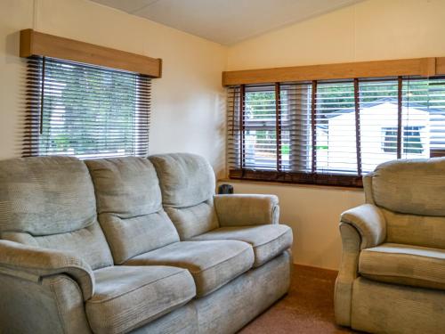 a living room with a couch and two chairs at Middlemuir Retreat in Tarbolton