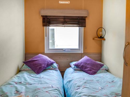 two beds in a small room with a window at Middlemuir Retreat in Tarbolton