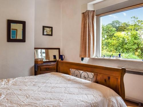 a bedroom with a bed and a window at Kiln Cottage in Bolton le Sands