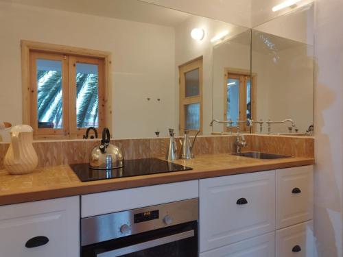 una cocina con 2 lavabos y un espejo grande en La Casita a 60 pasos del mar en Tamaduste