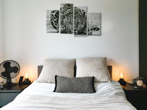 a bedroom with a bed with two pictures on the wall at Luxe Apartment: 3 mins Luton Airport & Free Wi-Fi in Luton