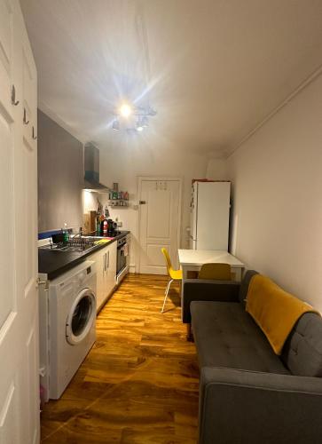 een woonkamer met een bank en een keuken bij 1 Bedroom Flat in Notting Hill, Portobello in Londen