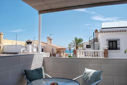 patio con mesa y sillas en el balcón en Casa del puerto, encanto junto al mar, en Estepona