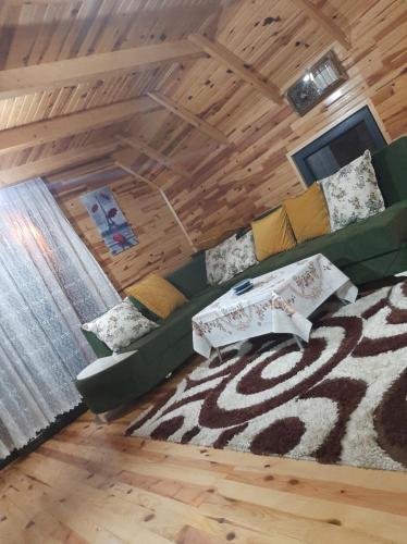 sala de estar con sofá verde y alfombra en Huzur Bungalow, en Macka