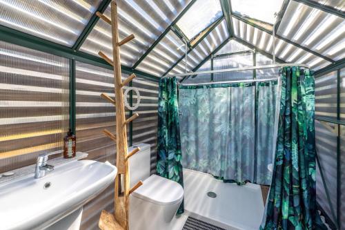a bathroom with a shower and a sink and a toilet at Welcome Cottage in Oneroa