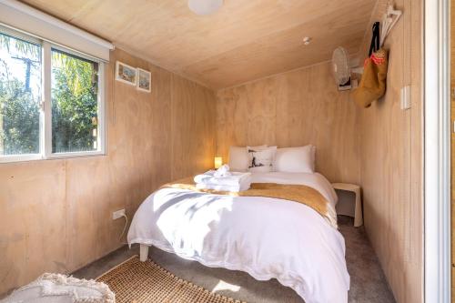 a bedroom with a bed in a small room at Welcome Cottage in Oneroa