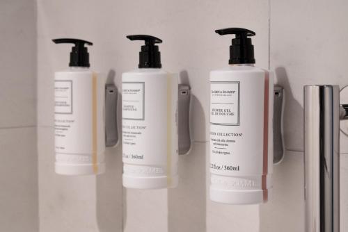 a group of three lotion bottles on a shelf at The Clancy, Autograph Collection in San Francisco