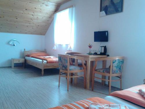 a bedroom with a desk and a table and a bed at Rooms Josip in Korenica