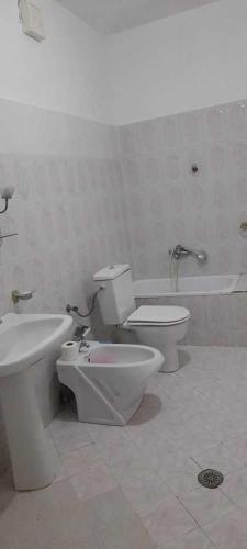 y baño con aseo, lavabo y bañera. en Sanos GardenApartament, en Sarandë