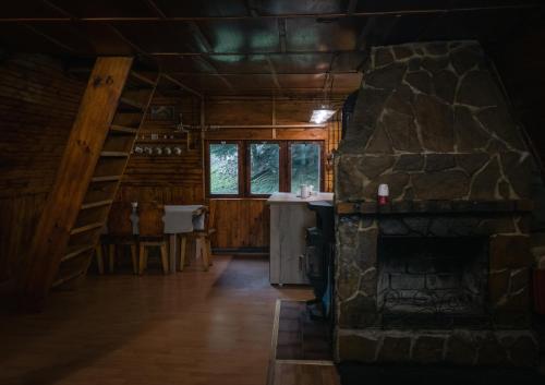 a room with a stone fireplace in a log cabin at Chata Jozef in Sabinov