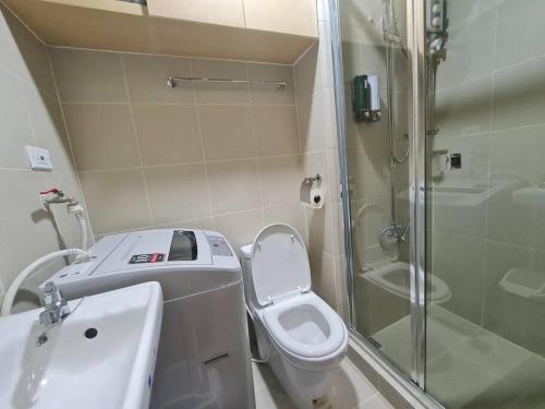 een badkamer met een douche, een toilet en een wastafel bij Chic 2 BR EDSA APT w/ Balcony Netflix Prime Video in Manilla