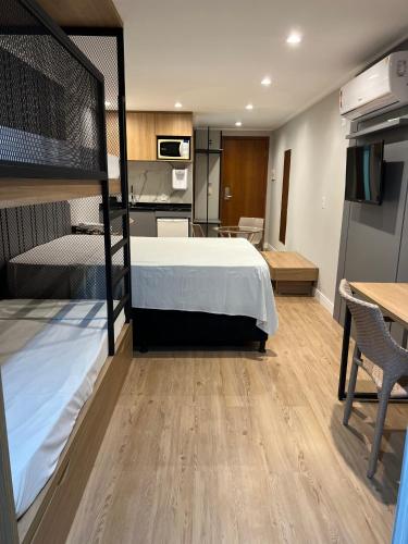 a room with a bed and a kitchen and a room with a bed gmaxwell gmaxwell at BLUE SUNSET PREMIUM - Flat Beira Mar para até 5 pessoas - Cabo Branco - Piscina Rooftop in João Pessoa