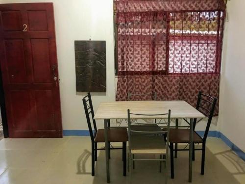 mesa y sillas en una habitación con puerta roja en Cabina Grande en Brasilito con piscina a 2 min caminando de playa brasilito, en Brasilito