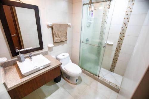 een badkamer met een douche, een toilet en een wastafel bij Suit 906 hermosa vista panorámica al Rio, Piscina. in Guayaquil