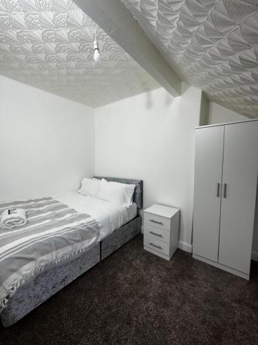 - une chambre avec un lit et une armoire blanche dans l'établissement Le Crescent Lodge, Room Stay , Middlesbrough City, à Middlesbrough