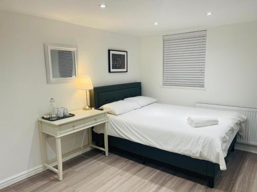 a bedroom with a bed with a nightstand and a bed sidx sidx sidx sidx at Riverside Premium En suite Double Room E14 in London