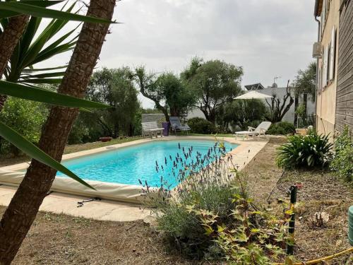 una piscina con una hamaca en un patio en Charming two bedroom villa with pool and garden, en La Gaude