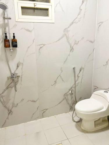 a white bathroom with a toilet and a shower at شقة جميلة بغرفتين نوم ومدخل خاص 2BB in Riyadh