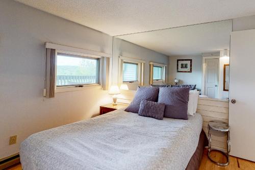 Schlafzimmer mit einem weißen Bett und einem Fenster in der Unterkunft Mountainside Resort B202 in Stowe