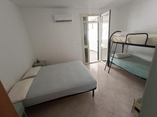 a bedroom with two bunk beds and a mirror at Stanze villa Morosini in Torre San Giovanni Ugento