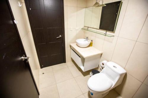 a bathroom with a toilet and a sink and a mirror at 1206 Increible suite en Puerto santa Ana in Guayaquil