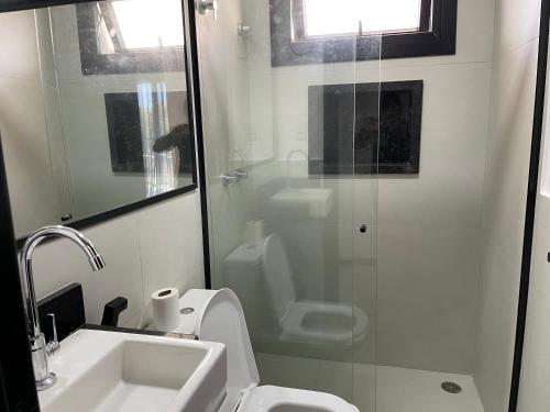 a bathroom with a toilet and a sink and a shower at INCRIVEL apartamento com vista lago! in Praia do Forte
