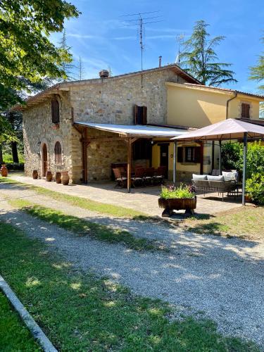 uma casa de pedra com um alpendre e um pátio em Casale Il Tiglio em Anghiari