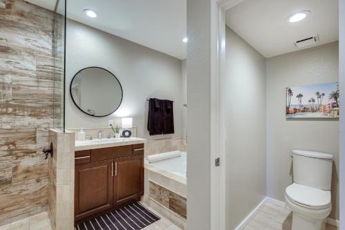 a bathroom with a toilet and a sink and a mirror at Beautiful Palm Desert Townhome with Community Perks! in Palm Desert