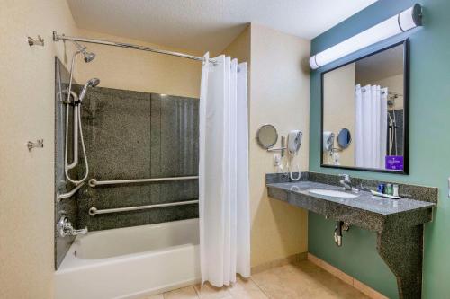 uma casa de banho com um chuveiro e um lavatório. em Sleep Inn & Suites em Rapid City
