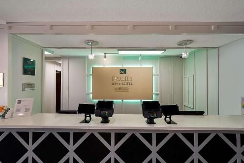 a room with a counter with chairs and a screen at Quality Inn & Suites Irving DFW Airport South in Irving