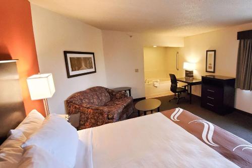 a hotel room with a bed and a couch and a desk at Quality Inn Atchison in Atchison