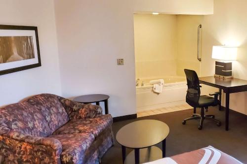 a living room with a couch and a table and a bathroom at Quality Inn Atchison in Atchison