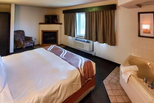 Atchison的住宿－Quality Inn Atchison，酒店客房配有一张床和浴缸。