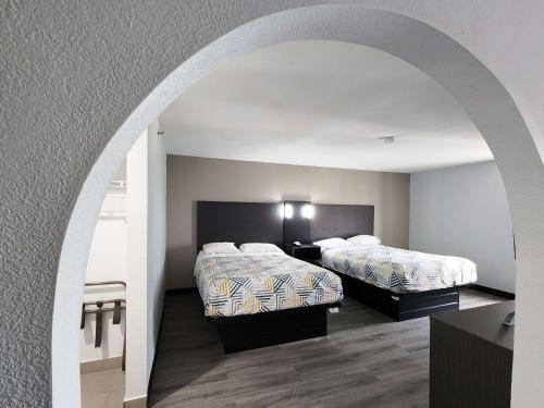 two beds in a hotel room with an archway at Motel 6-Pine Bluff, AR in Pine Bluff