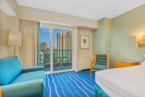 a hotel room with a bed and a balcony at CASTLE at Ala Moana Hotel in Honolulu