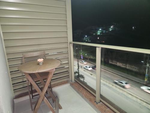 a small table on a balcony with a view of a highway at Via Premiere Suíte 409 B in Rio de Janeiro
