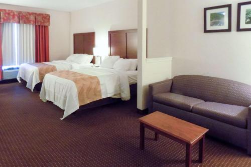 a hotel room with two beds and a couch at Quality Inn Kingdom City, MO in Kingdom City