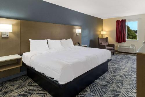 un grande letto bianco in una camera d'albergo di Econo Lodge Cherry Point a Havelock