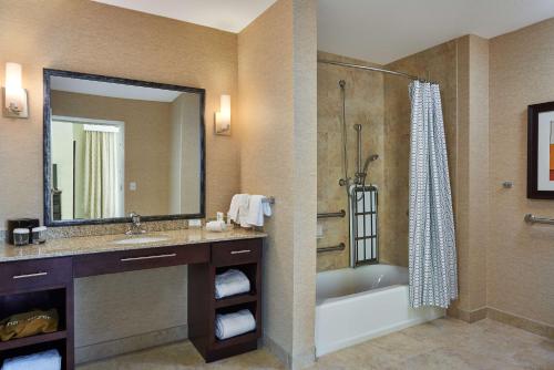 een badkamer met een bad, een wastafel en een douche bij Homewood Suites Odessa in Odessa