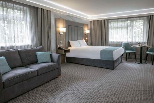 una camera d'albergo con letto e divano di Best Western Premier Heronston Hotel & Spa a Bridgend